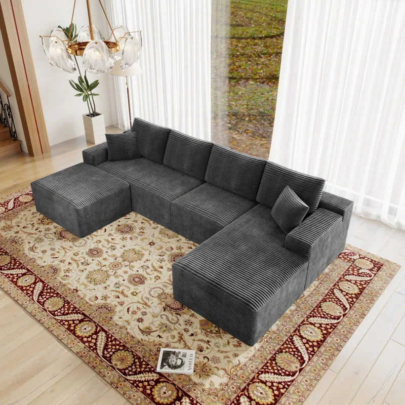 Gray sectional sofa in a living room with a patterned rug and decorative elements.