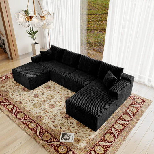Black sectional sofa in a living room with a patterned rug and decorative elements.